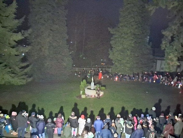 St. Martin reitet auf einem Pferd, die Kinder stehen mit ihren Laternen im Kreis